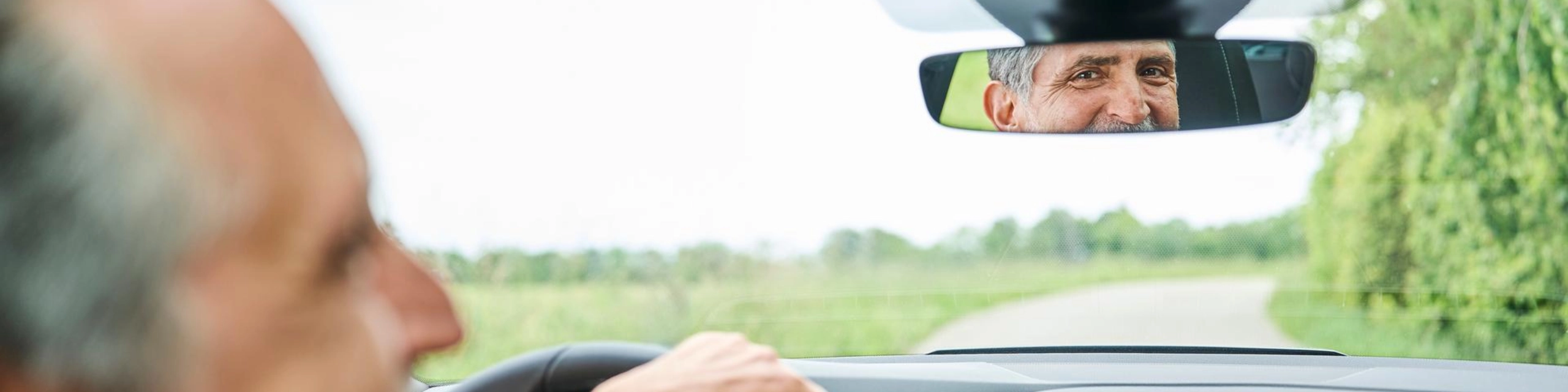 Homem dirigindo relaxado pela paisagem - transmite uma sensação de liberdade através de um leasing
