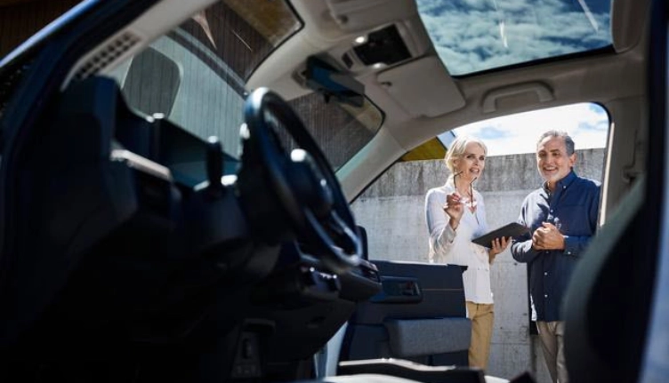 Leasing handover situation - view from the driver's seat to two people outside