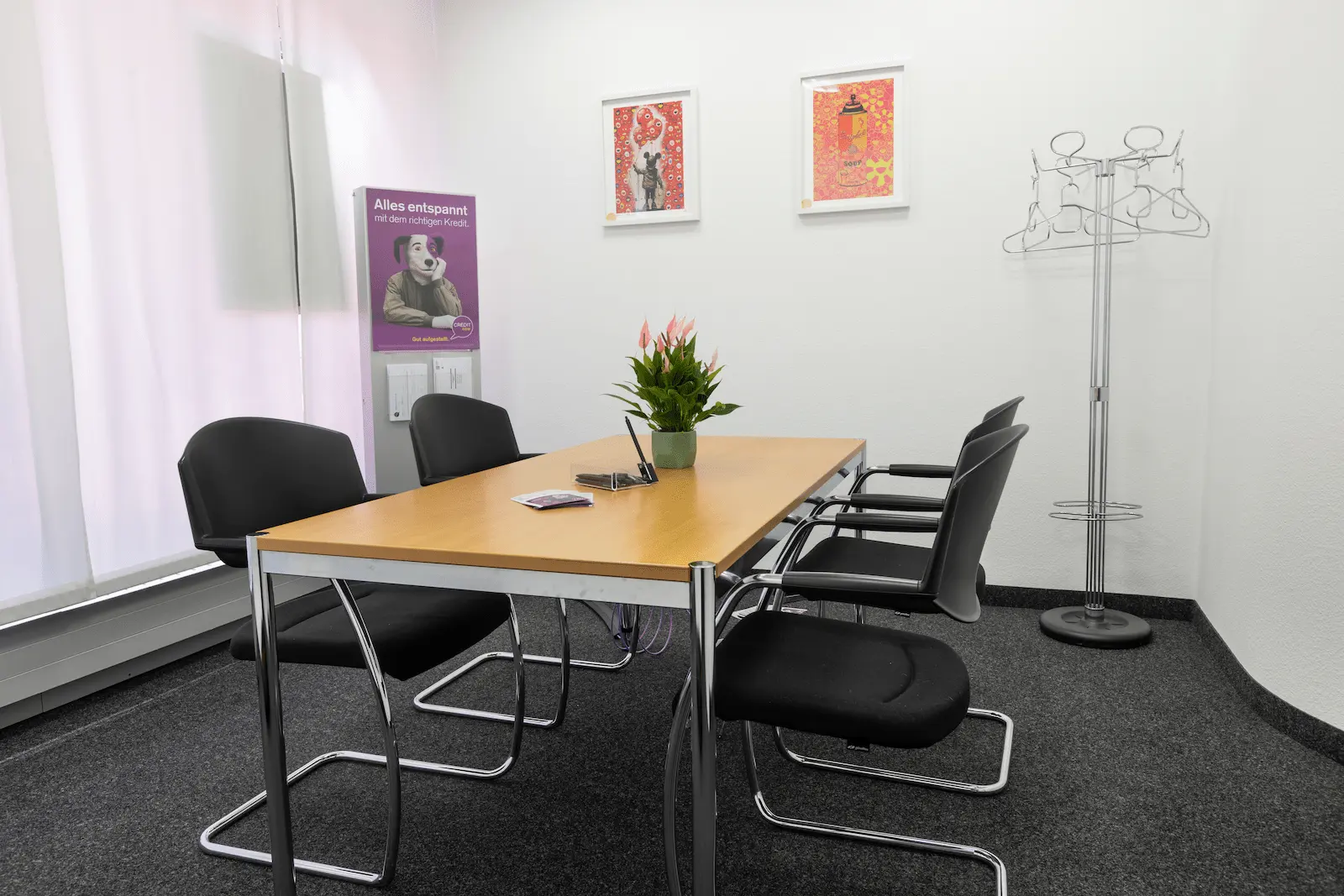 Besprechungsraum der BANK-now Filiale Olten mit rundem Tisch, Stühlen und grossem Fenster.